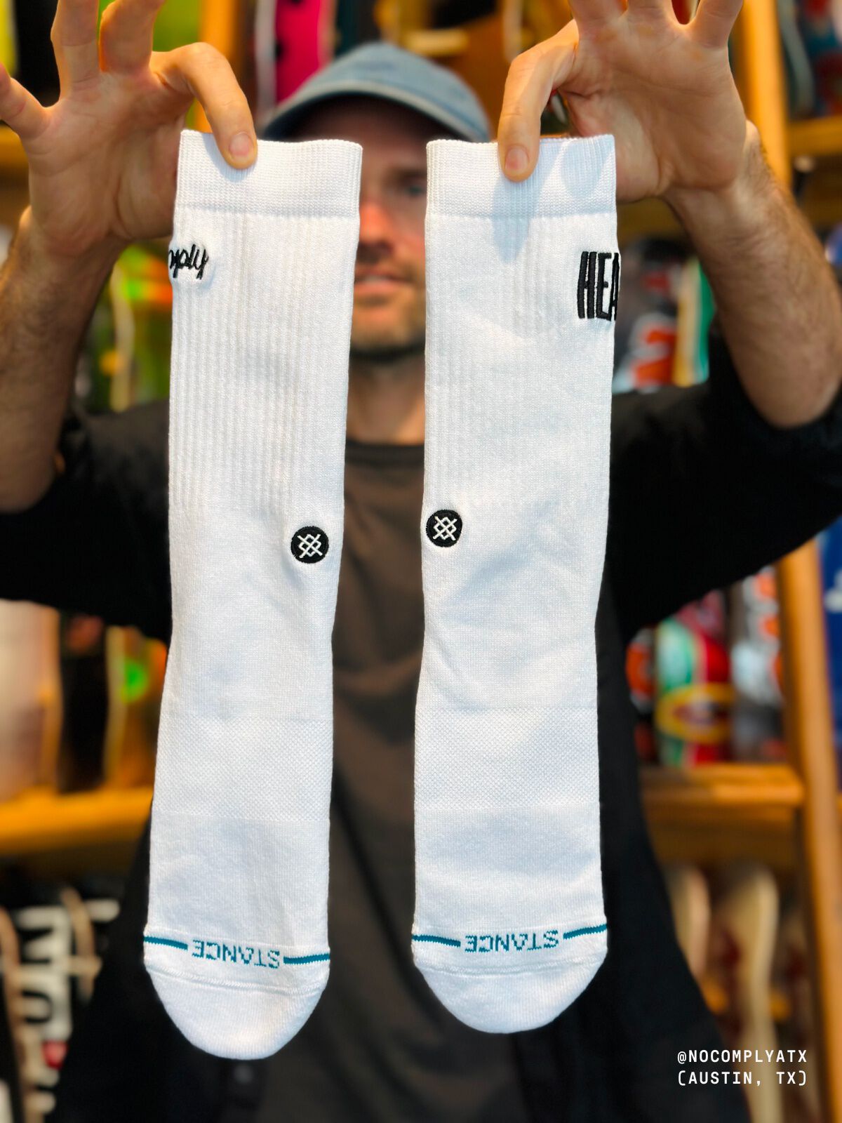 Photo of a person holding up a pair of white socks.