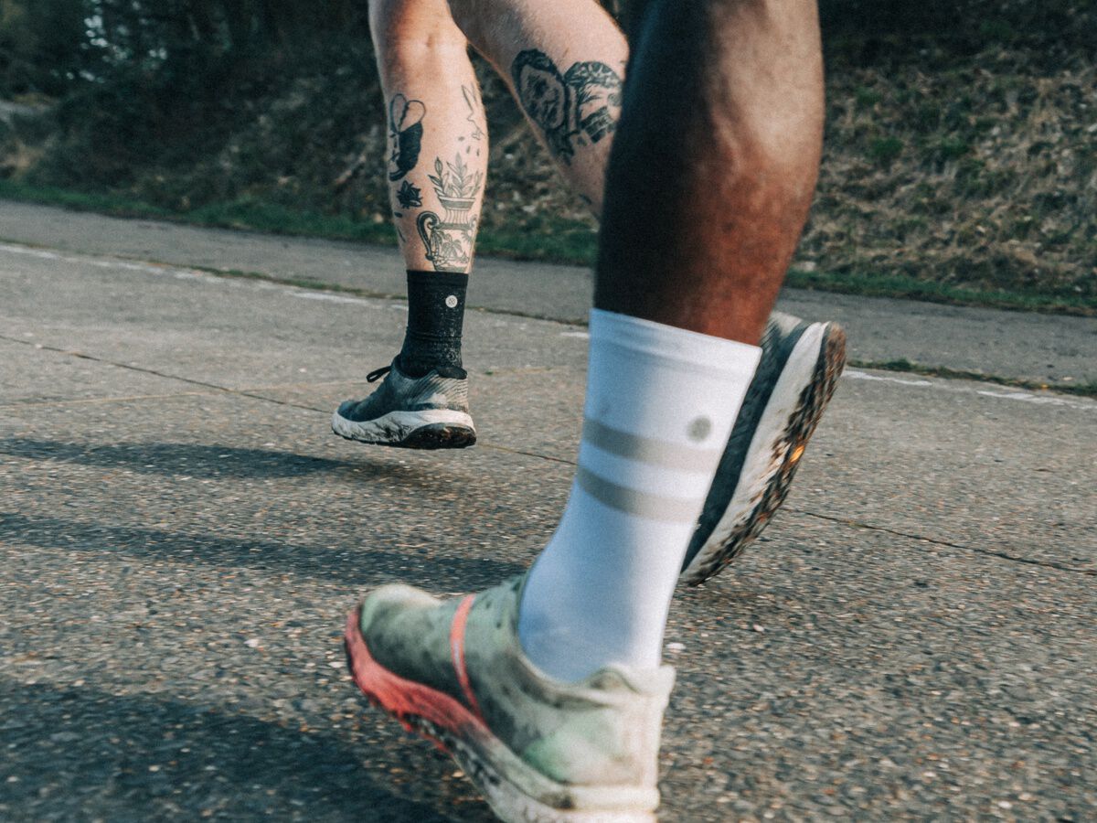 a zoomed in image of two people running wearing stance performance crew socks.